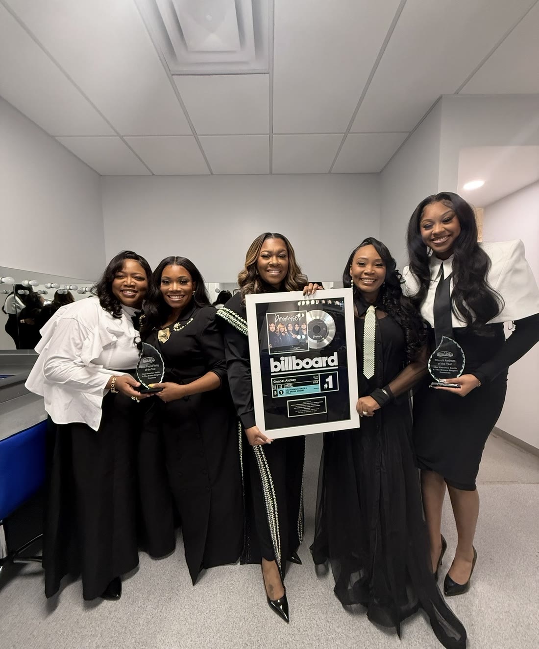 Lisa Knowles-Smith holding the Billboard Gospel Airplay No. 1 plaque for Promises, with the group